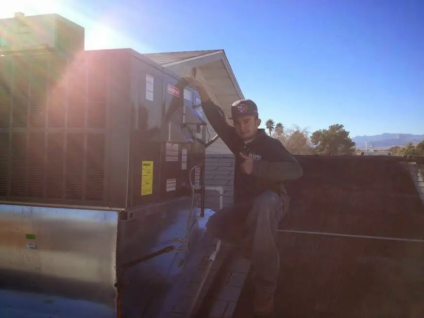 HVAC technician performing Heat Pump Repair on a rooftop unit in Lincoln